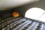 Enjoy a cozy night in your RV rental! This comfy bed with a striped blanket and lion plush awaits your adventure.