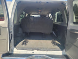 View of an RV rental van's open rear cargo area. Dark bench seat & floor mounts highlight flexible interior space for travel.