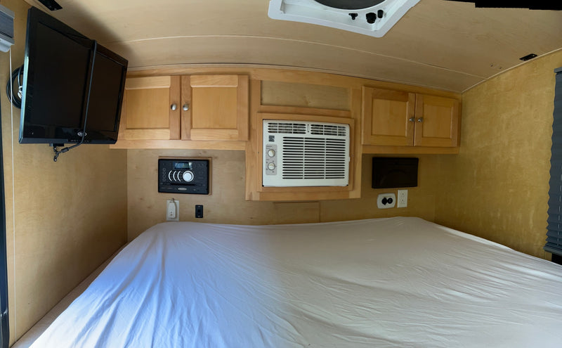  and a window for travel.|This cozy RV rental interior features a bed with white sheets — photo 6