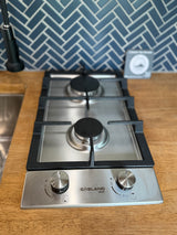 This Gasland Chef 2-burner gas cooktop is perfect for an RV rental kitchen, featuring a wood counter and blue tile backsplash.