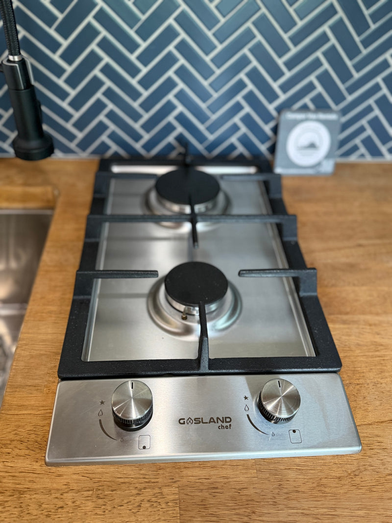 This Gasland Chef 2-burner gas cooktop is perfect for an RV rental kitchen, featuring a wood counter and blue tile backsplash. — photo 19