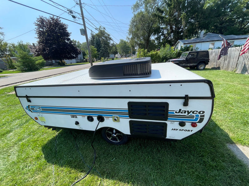 This white Jayco Jay Sport pop-up camper with a rooftop AC unit is ready for your next RV rental adventure. — photo 9
