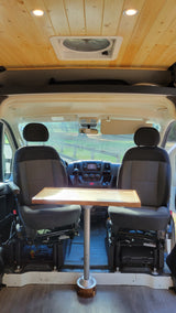 RV rental: van conversion interior with swiveling front seats, a table, wooden ceiling, and roof vent.