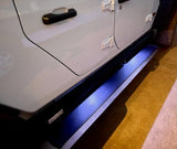 Side of white vehicle with bright blue illuminated automatic running boards. Great for accessible entry, enhancing any rv rental journey.