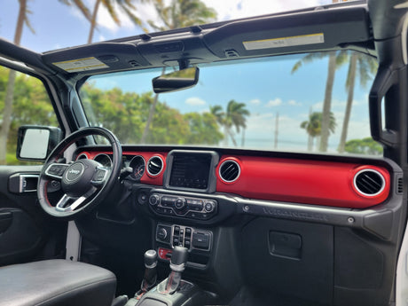 Jeep Wrangler RV rental interior with a vibrant red dash, open roof, & tropical views. Your adventure vehicle awaits!