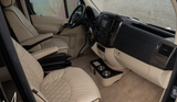 Inside a luxury RV rental: cream quilted seats, modern dashboard, and custom console offer ultimate comfort.