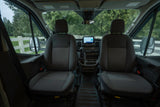 Inside an RV rental: front cabin with seats, dashboard display, and wet windshield view.