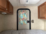 RV rental interior: cozy sleeping area with bed, wood cabinets, and AC.