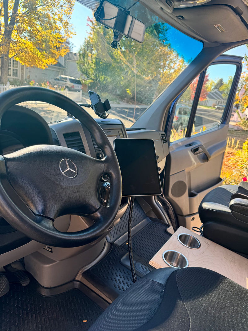  parked outdoors with its driver's door open.|Spacious front cabin of an RV rental van. Features comfortable seats — photo 7