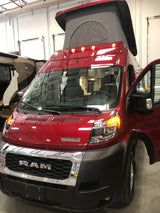 A vibrant red Winnebago pop-top camper van, built on a Ram ProMaster chassis, available for RV rental.
