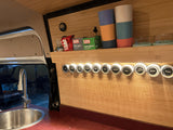 This RV rental's compact kitchen boasts a sink, an organized spice rack, and tea supplies, maximizing small space utility.