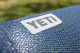 Enjoy comfort on your RV rental adventure! Close-up of a YETI logo patch on blue woven outdoor gear.