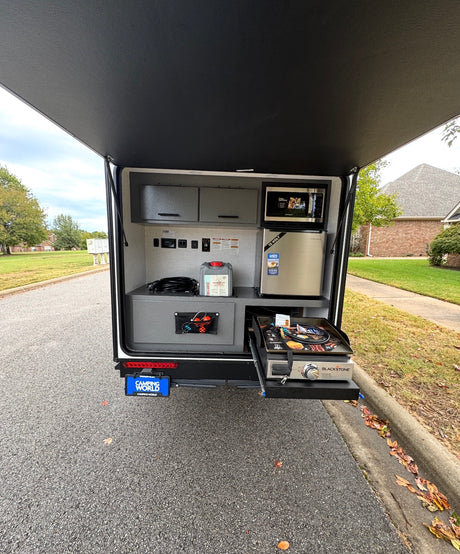 This rv rental boasts an outdoor kitchen, featuring a microwave, fridge, and pull-out Blackstone griddle for convenient camping meals.