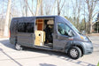This gray Ram ProMaster rv rental campervan shows its open side door revealing a custom wood interior, ready for adventure.