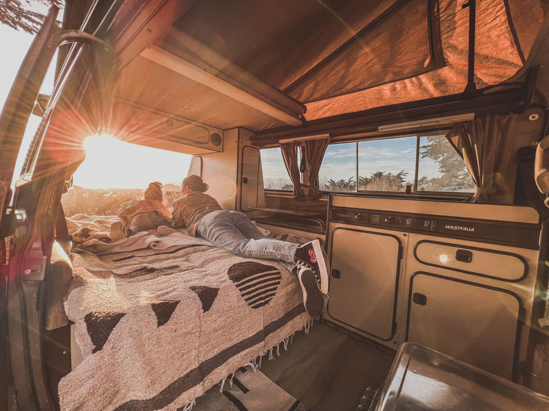  perfect for a scenic road trip.|A person relaxing on a bed in an RV rental camper van — photo 8