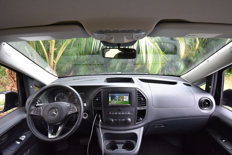  and cup holders. Green tropical view.|This RV rental's camper van interior features rear seats — photo 7