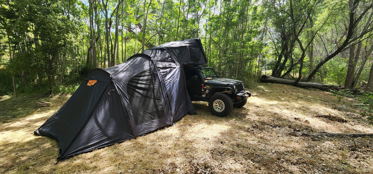 The slide-in annex fully zipped on beneath the rooftop tent, enclosing the ground area alongside the vehicle — photo 4