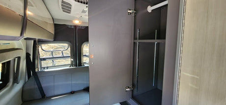 Inside an RV rental: a versatile closet with hanging rod & adjustable shelves, and a comfortable rear bench seat.