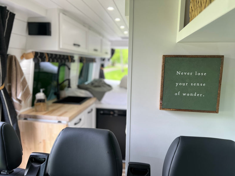 Spacious RV rental interior with kitchen, comfy seats, and a "sense of wonder" sign. Perfect for adventure! — photo 17