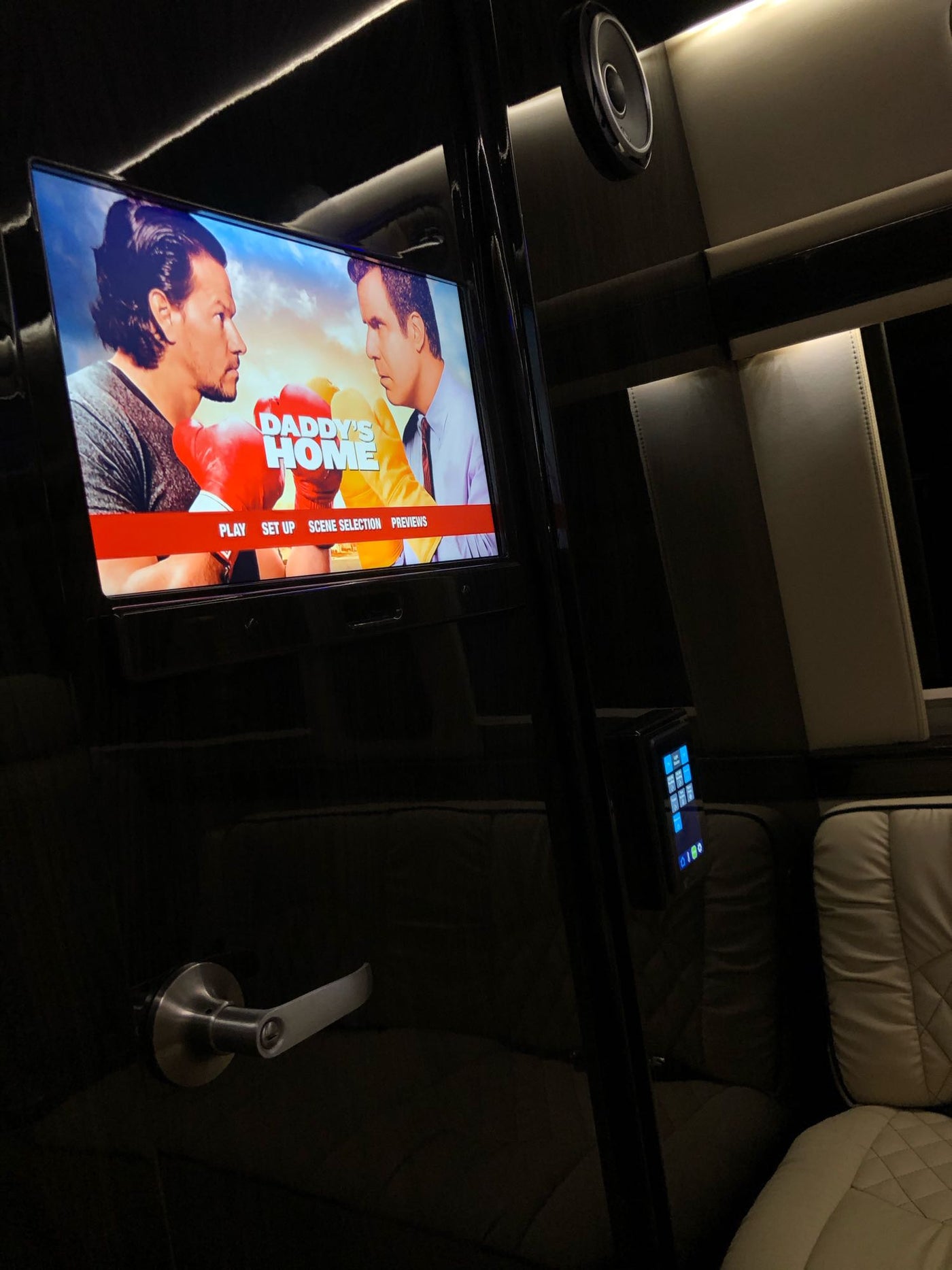Luxury RV rental interior with a TV playing "Daddy's Home", plush seating, and ambient lighting for ultimate comfort. — photo 13