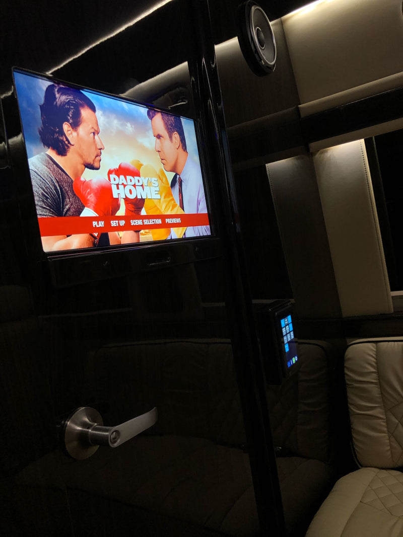 Luxury RV rental interior with a TV playing "Daddy's Home", plush seating, and ambient lighting for ultimate comfort. — photo 13