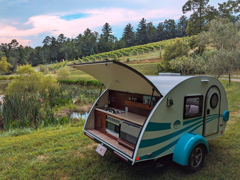 This cozy teardrop RV rental, with its outdoor kitchen, is perfectly set by a pond and vineyard for a serene camping trip. — photo 2