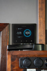 RV rental interior with a Simarine smart monitor showing 100% battery, time, pressure, and system data.