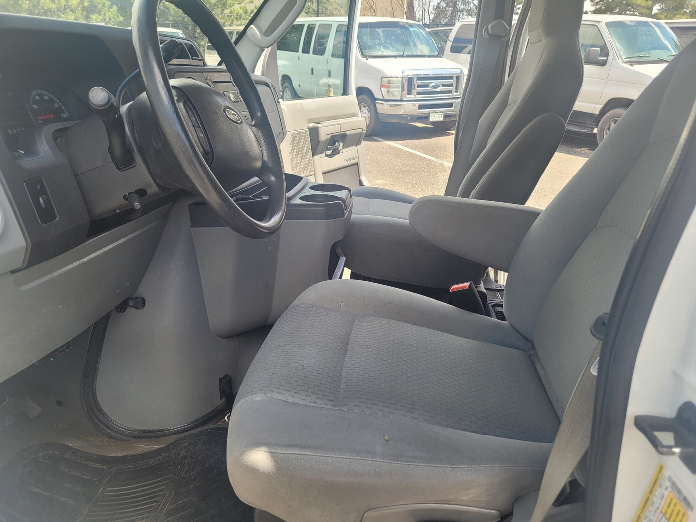 Interior of a white Ford E-Series van, highlighting the driver's area. Great for an rv rental or utility use. — photo 9