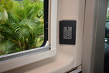 Modern RV rental interior featuring a window with a lush green view and a convenient USB and AC power outlet.