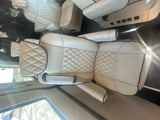 Luxury cream diamond-stitched seating inside an RV rental. Comfortable interior with black piping and visible seatbelts.
