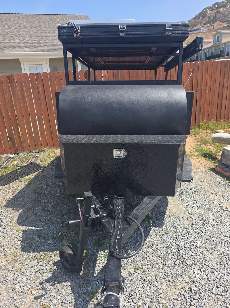 Front view of a rugged black utility trailer with a rooftop tent and storage, perfect for an rv rental adventure. — photo 4