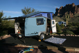 Enjoy desert adventures! This compact teardrop RV rental, with its pop-top tent, offers cozy camping amidst mountains & cacti.