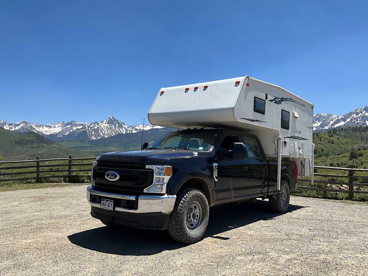  backed by snowy mountains. Perfect for your RV rental adventure!|Sunset view of a truck with a Northstar RV rental camper — photo 4