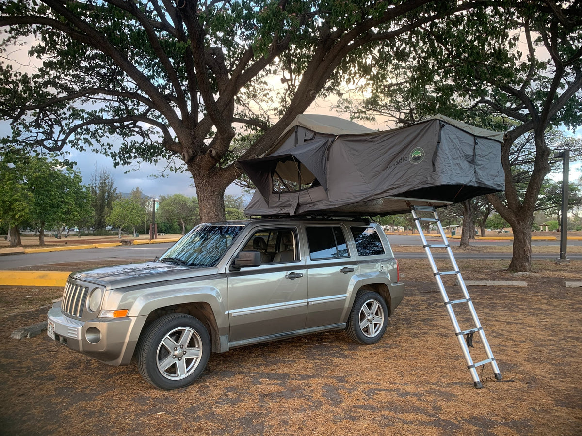 This grey SUV, equipped with a roof-top tent and ladder, makes for a compact RV rental, perfect for outdoor camping. — photo 6