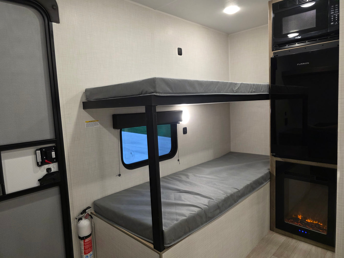 RV rental: Bunk beds, microwave, TV, fireplace, and fire extinguisher for a cozy journey.