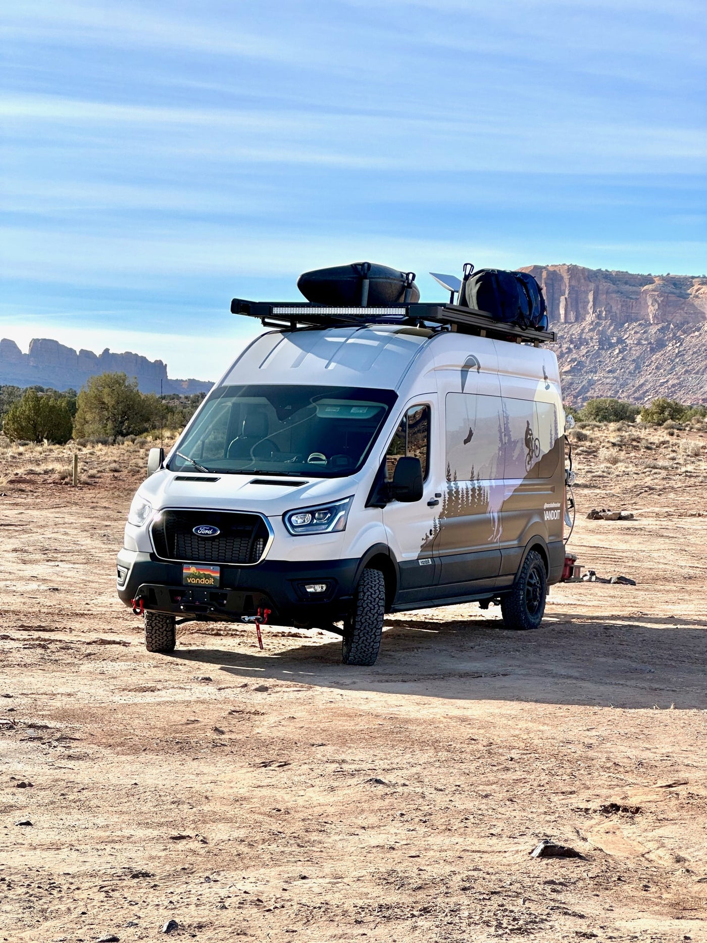  snowboards & roof gear at a snowy sunset.|A white and black custom adventure van (perfect for RV rental) with mountain biking — photo 4