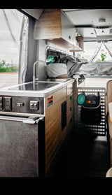 Comfortable rv rental interior: compact kitchen with sink, cozy bed, and smart storage for your adventures on the road.