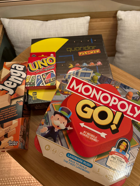 Essential board games for an RV rental getaway: Jenga, UNO, Monopoly Go!, and Quoridor Pac-Man.