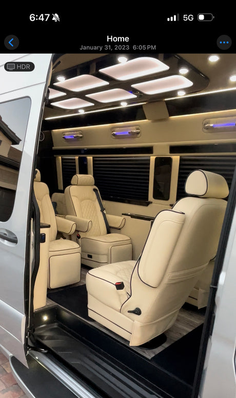 This luxury RV rental features a spacious custom interior with cream captain's chairs, ambient lighting, and privacy blinds.