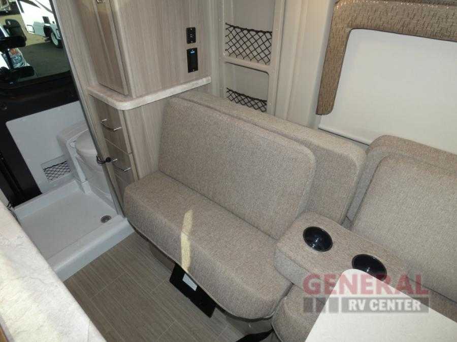Cozy RV rental interior featuring reclinable seating, a compact wet bath, and storage cabinetry. Ideal camper travel. — photo 6