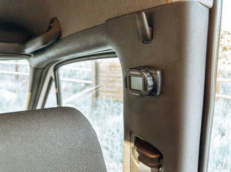 Webasto SmartTemp heater control on the pillar inside an RV rental. Offers warmth, with a snowy outdoor scene visible.