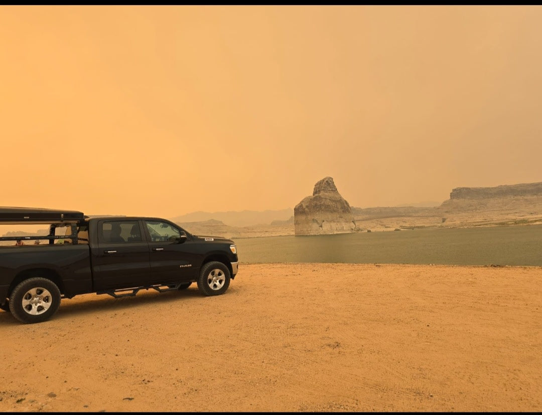 Black Ram pickup truck with iKamper rooftop tent and ladder on gravel. Perfect setup for an rv rental camping trip.|Black Ram pickup under the iconic Route 66 Kingman