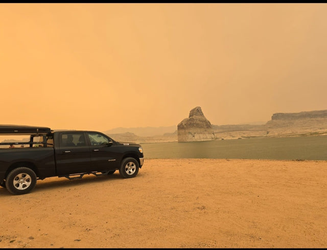 Black Ram pickup truck with iKamper rooftop tent and ladder on gravel. Perfect setup for an rv rental camping trip.|Black Ram pickup under the iconic Route 66 Kingman