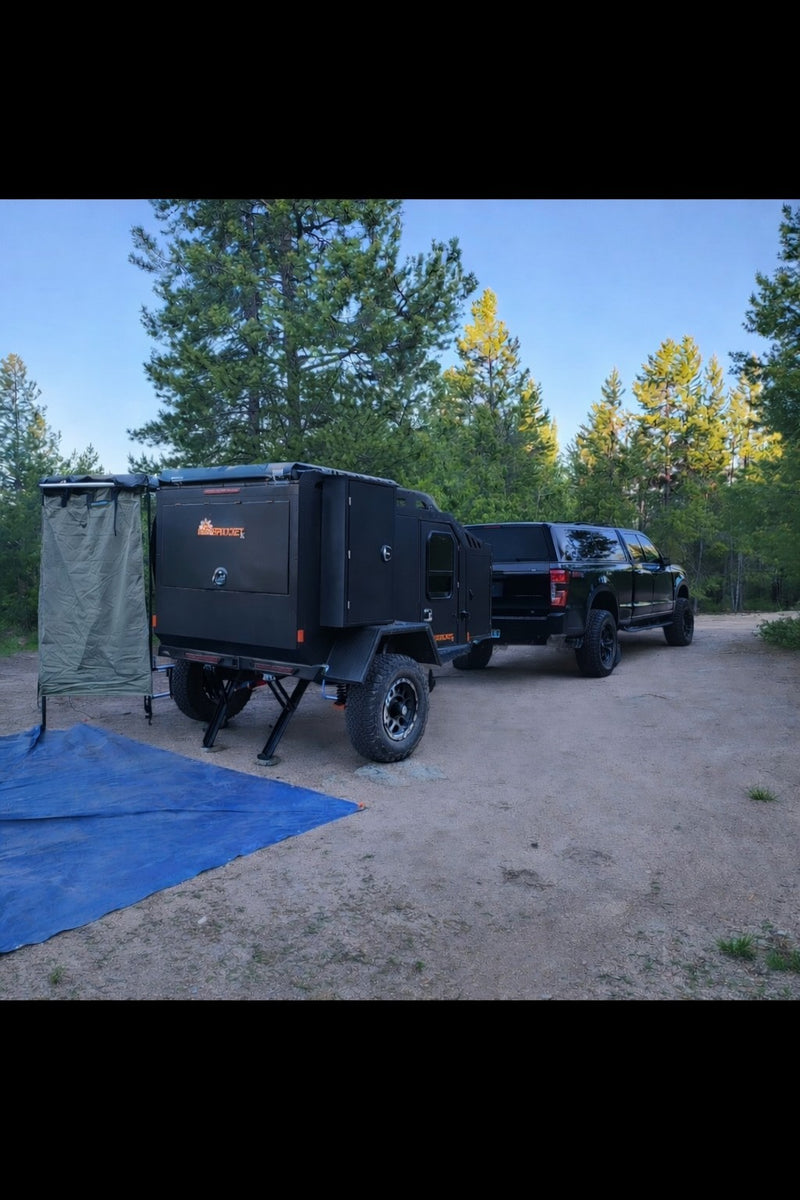  awning & truck at a forest campsite. Includes blue tarp & chair.|This rugged overland trailer — photo 3