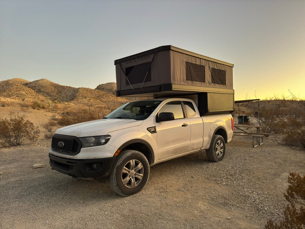 Adventure-ready truck with a pop-top camper, offering an RV rental-like experience for desert camping and outdoor adventure.