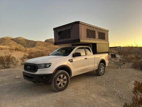 Adventure-ready truck with a pop-top camper, offering an RV rental-like experience for desert camping and outdoor adventure.