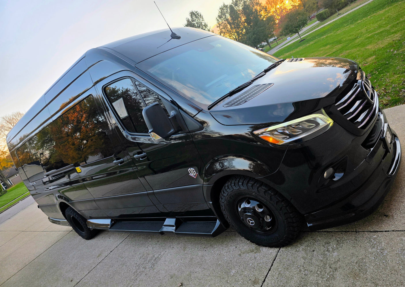 Custom black Mercedes-Benz Sprinter van, perfect for RV rental adventures, parked on a concrete drive.