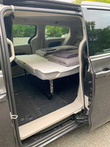 Inside a minivan RV rental: A clever bed conversion for comfortable road trips and camping.