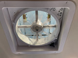 An RV rental features a white ceiling fan with a protective screen, offering ventilation and fresh air inside.
