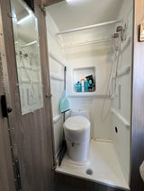 Compact RV rental bathroom with integrated shower, toilet, and toiletries. Practical wet bath design for travel.